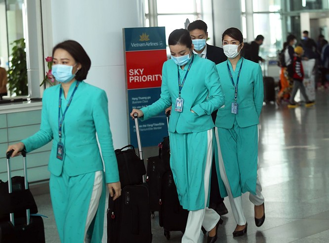Tiếp viên hàng không đeo khẩu trang trước khi lên máy bay tại sân bay Nội Bài. Ảnh: Gia Chính.