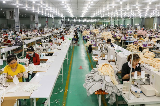 Công nhân của Công ty GarmentTech Pro (Khu công nghiệp Tân Đô, huyện Đức Hòa, Long An) sản xuất khẩu trang vải. Ảnh: Quỳnh Trần.