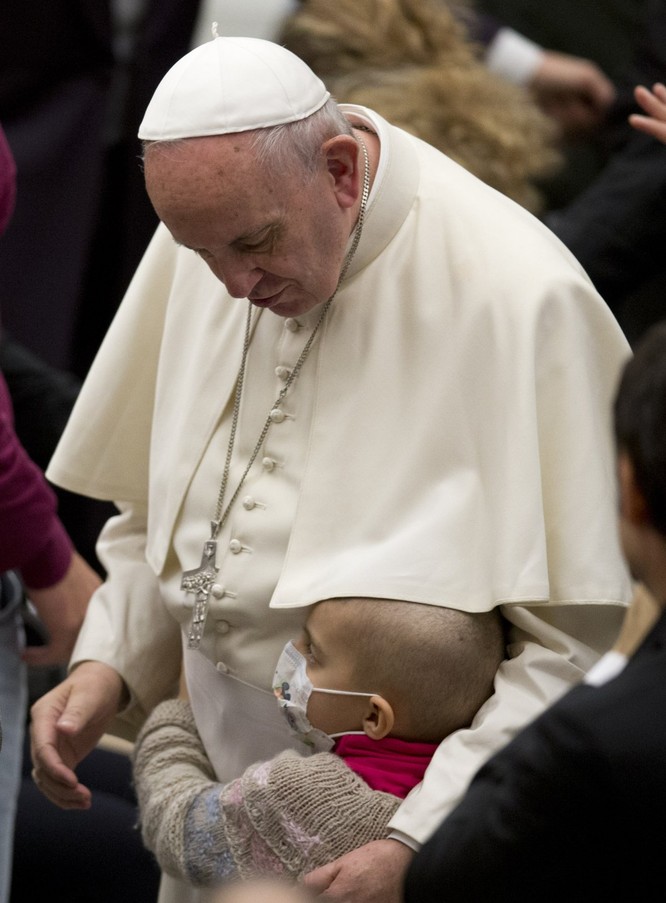 Giáo hoàng Francis được ôm một đứa trẻ vào cuối buổi tiếp kiến chung hàng tuần của ông trong sảnh đường Phaolô VI ở Vatican, thứ Tư ngày13/1 vừa qua.