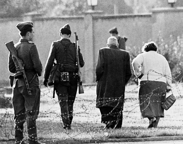 Vài thiếu niên Đông Đức với những khẩu súng đồ chơi, chơi trò đóng giả làm cảnh sát khi chúng nhìn về phía bức tường bê tông ở Bernauer Strasse năm 1961.