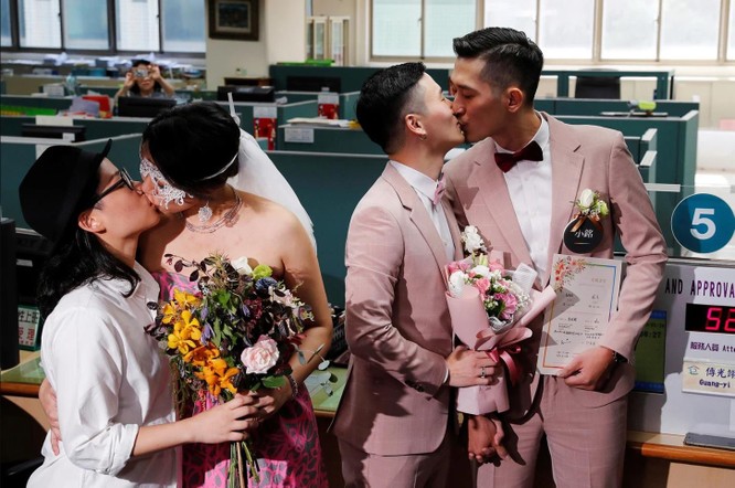 Hai cặp đôi Shane Lin – Marc Yuan (phải) cùng cặp đôi Cynical Chick – Li Ying-Chien có pha “khóa môi” sau khi đăng ký thủ tục kết hôn ở Văn phòng Đăng ký Hộ gia đình ở Đài Bắc hôm 24/5 (Ảnh: Reuters)