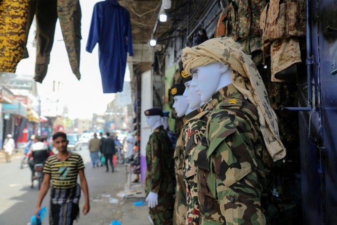 Các bộ áo lính treo bên ngoài một cửa hàng ở chợ truyền thống Taez (Ảnh: AFP)