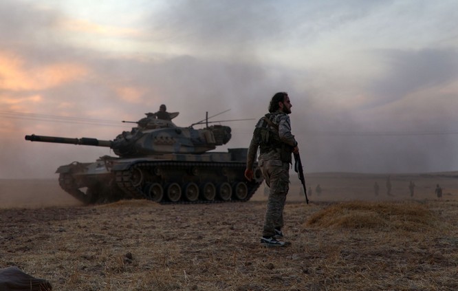 Một chiến binh thuộc lực lượng Thổ Nhĩ Kỳ hậu thuẫn đứng cạnh chiếc xe tăng M60 do Mỹ sản xuất bên ngoài thị trấn Manbij (Ảnh: AFP)