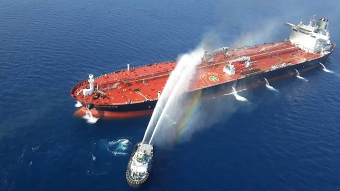 Tàu Iran cố gắng dập lửa trên con tàu chở dầu sau khi nó bị tấn công trên Vịnh Oman (Ảnh: Reuters)