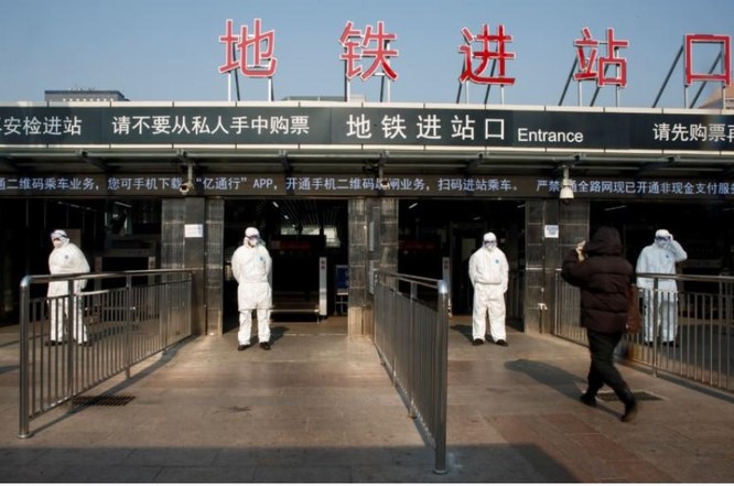 Nhân viên y tế kiểm tra thân nhiệt hành khách tại trạm xe lửa trung tâm Bắc Kinh (Ảnh: Reuters)