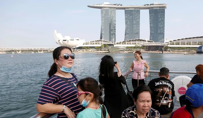 Du khách đứng ngắm cảnh tại Marina Bay Sands, Singapore (Ảnh: SCMP)