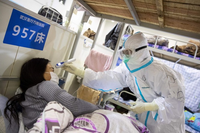 Bác sĩ thăm khám một bệnh nhân nhiễm COVID-19 ở Trung Quốc (Ảnh: AFP)