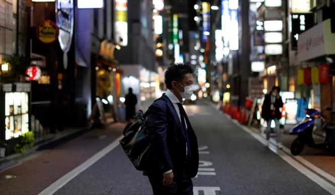 Một người đàn ông mang khẩu trang đi bộ ở khu Ginza, thủ đô Tokyo, Nhật Bản (France24)
