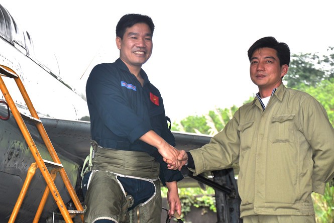 Phi công Nguyễn Hữu Cường (bìa trái, một trong 2 phi công mất tích) được nhân viên kỹ thuật đón xuống sân bay khi kết thúc chuyến bay huấn luyện bằng Mig-21 tại sân bay quân sự Yên Bái, tháng 2.2013 ẢNH: MAI THANH HẢI