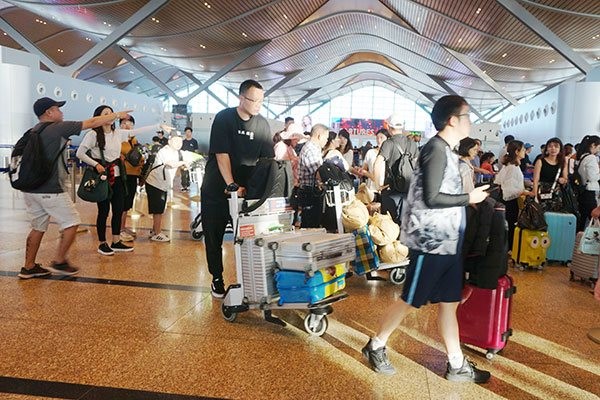 Du khách Trung Quốc làm thủ tục hàng không trước khi về nước tại Sân bay Quốc tế Cam Ranh. Ảnh: Minh Duy