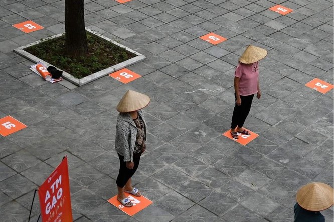 Người dân đứng cách xa nhau đợi lấy gạo miễn phí tại Hà Nội