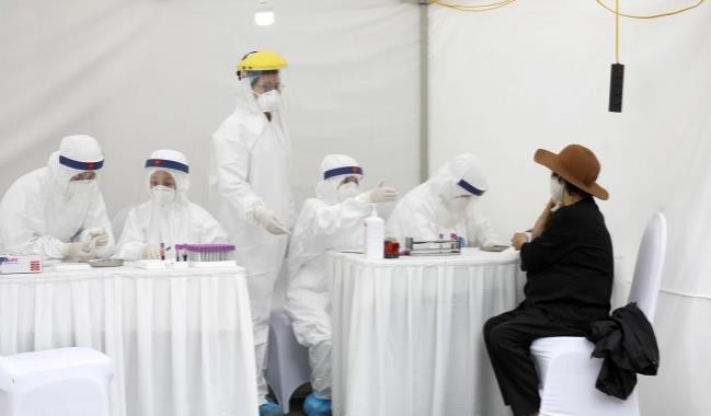 Một người phụ nữ được xét nghiệm Covid-19 tại các trạm xét nghiệm nhanh ở Hà Nội