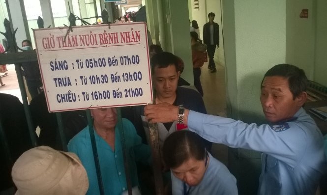 Người dân đừng bên ngoài cổng ra vào bệnh viện Đà Nẵng để theo dõi việc diễn tập mà bệnh viện này đang triển khai - Ảnh: Tấn Vũ