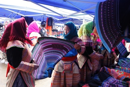 Phụ nữ Mông chọn vải để may trang phục.