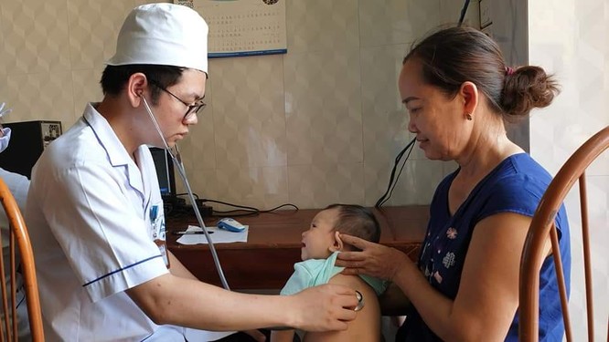 Bác sĩ khám sàng lọc cho trẻ trước khi tiêm.