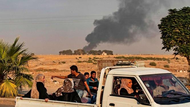 Người dân tháo chạy trong lúc cột khói lớn bốc lên từ thị trấn Ras al-Ain, Đông Bắc Syria sau đòn không kích của Thổ Nhĩ Kỳ (Ảnh: ABC)