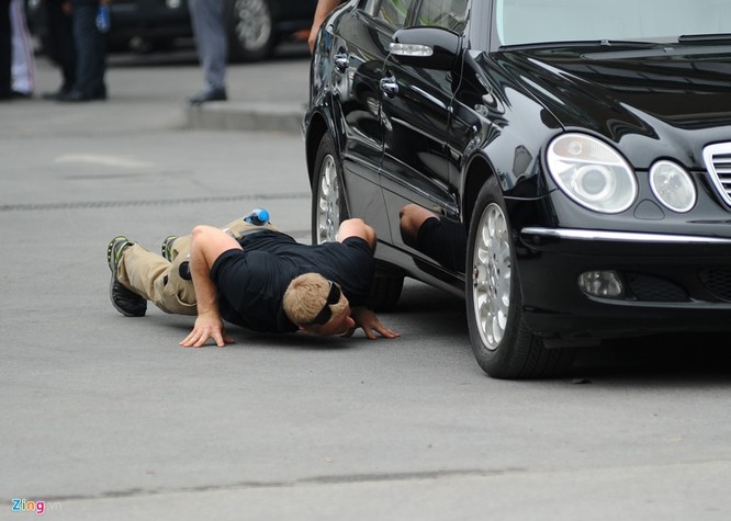 Đặc vụ Mỹ nằm rạp xuống đất để kiểm tra xe. Việc này được tiến hành thường xuyên, nhiều lần trước khi đoàn xe của Tổng thống Obama xuất phát.