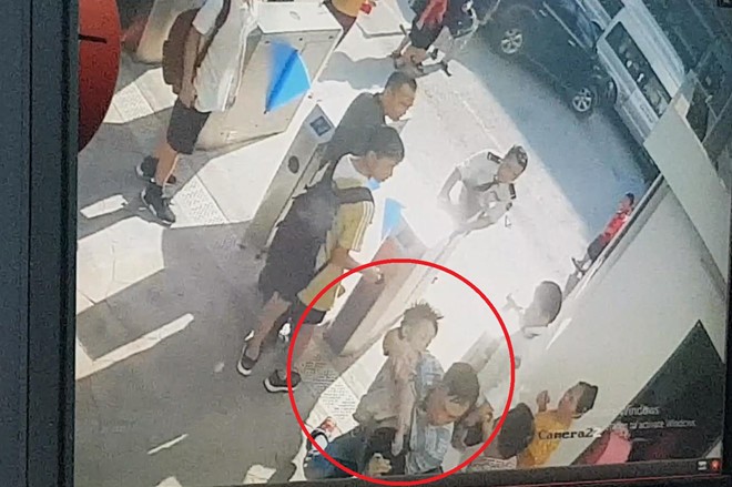 Hình ảnh từ camera an ninh cho thấy bé Long mặc áo trắng lúc được đưa vào phòng cấp cứu của nhà trường 