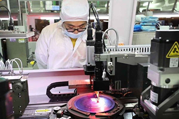 Máy khắc tia cực tím là thiết bị quan trọng để sản xuất chip bán dẫn. Trong ảnh, công nhân một nhà máy ở Giang Tô thao tác máy quang khắc sản xuất chip (Ảnh: AFP).