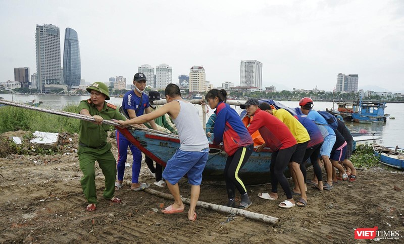 Lực lượng công an hỗ trợ người dân đưa tàu thuyền lên bờ tránh bão
