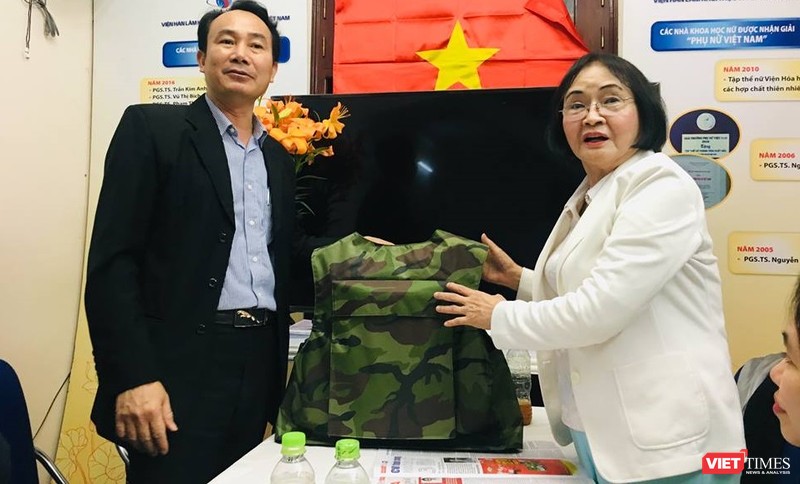 Đại diện Z117 và PGS.TS. Nguyễn Thị Hòe giới thiệu chiếc áo chống đạn sẽ được sử dụng sơn chống đạn và sơn chống cháy. (Ảnh: T.H)
