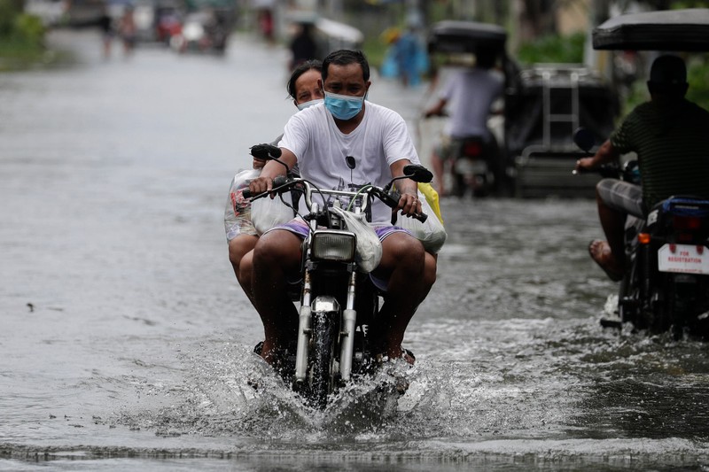 Một người đàn ông lái xe máy trong lúc bão Molave đổ bộ vào tỉnh Pampanga của Philippines (Ảnh: AP)