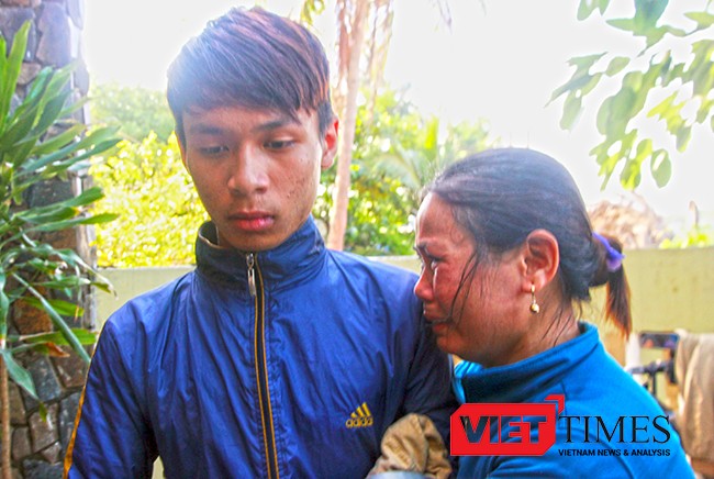 Bà Nguyễn Thị Năng (vợ ông Võ Văn Lựu, thuyền trưởng tàu QNg 90479TS) như không còn sức lực để khóc. Vùi đầu vào cậu con trai mới 16 tuổi Võ Văn Cầu trở về sau cơn hoạn nạn.