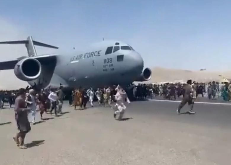 Cảnh người dân bám và chạy theo khi chiếc C-17 cất cánh (Ảnh: Đông Phương).