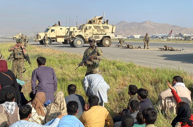 Quân đội Mỹ triển khai ở sân bay Kabul ngăn cản những người Afghanistan tràn vào đường băng, bảo vệ việc triệt thoái kiều dân và những người đã làm việc cho Mỹ (Ảnh: AP)