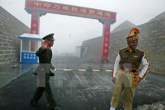 Binh sĩ Trung Quốc (trái) và binh sĩ Ấn Độ tuần tra tại cửa khẩu Nathu La trên biên giới Ấn Độ - Trung Quốc. (Nguồn: AFP/TTXVN)
