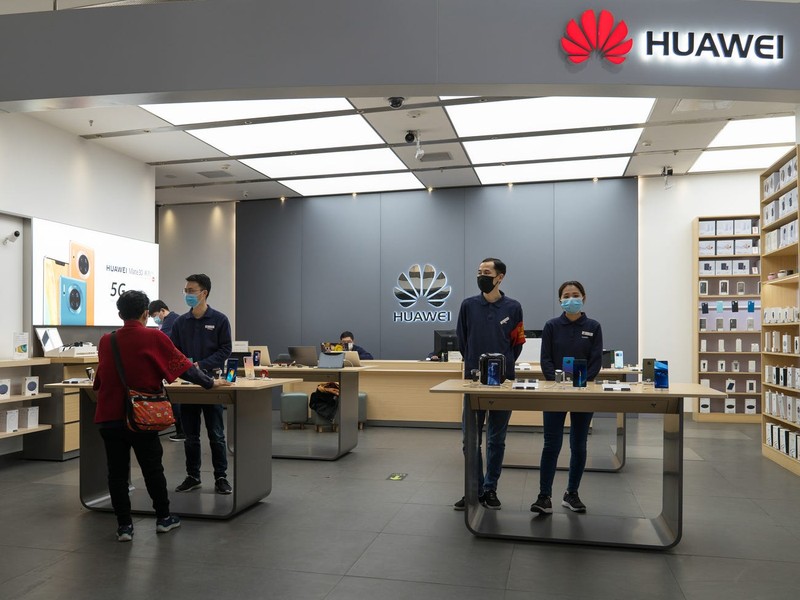 Các nhân viên bán hàng của Huawei đeo khẩu trang tại một cửa hàng của hãng ở Bắc Kinh, Trung Quốc. Ảnh: Business Insider