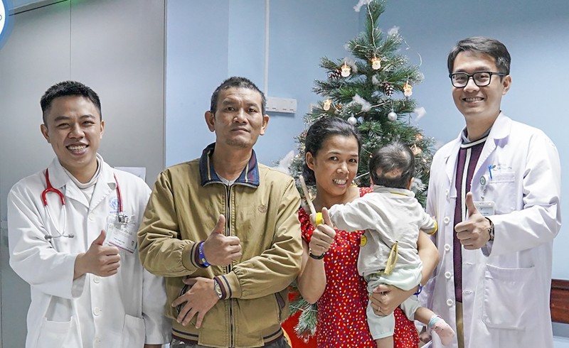 Bố và mẹ bé K.N, cùng bác sĩ điều trị trong niềm vui trước ngày ra viện