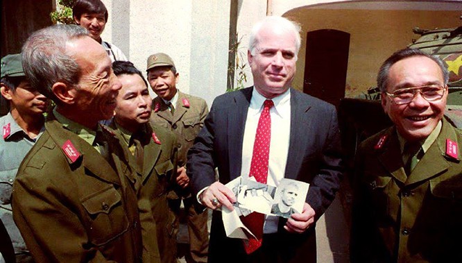 2-	Thượng nghị sỹ John McCain cầm những tấm hình đen trắng chụp ông khi bị bắt làm tù binh ở Hà Nội năm 1967 trong một chuyến đến thăm Bảo tàng quân đội nhân dân Việt Nam ngày 9/10/1992.Ảnh: Hoàng Đình Nam/ AFP.