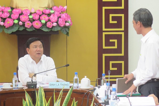Bí thư Quận ủy Q.1 Huỳnh Thanh Hải đang báo cáo tình hình kinh tế ở Q.1 với Bí thư Thành ủy TP.HCM Đinh La Thăng - Ảnh: Trung Hiếu