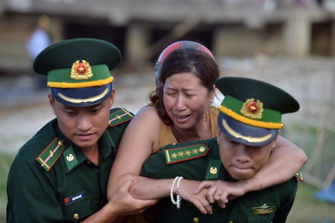 Vợ của nạn nhân Phạm Tấn Cường khóc ngất trong khi được lực lượng biên phòng Đà Nẵng dìu đi - Ảnh: LÊ HẢI SƠN