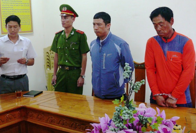 Cơ quan công an đọc lệnh khởi tố bắt tạm giam đối với Lee Jae Myecong (áo đỏ) và Jong Wook (áo khoác xanh) - Ảnh: Văn Định