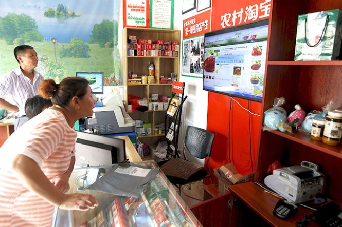 Người dân đến xem mua hàng ở cửa hàng của Alibaba ở thôn Kim Gia, TP Đồng Lư, tỉnh Chiết Giang. Tập đoàn bán lẻ qua mạng cho rằng thị trường nông thôn sẽ đem lại doanh thu đến 74 tỉ USD - Ảnh: Reuters