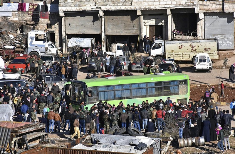 Phiến quân thất trận lên xe rời khỏi thành phố Aleppo