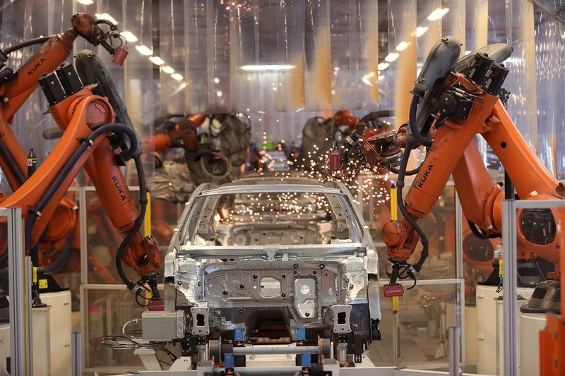 Cánh tay robot hoạt động trên dây chuyền sản xuất bên trong nhà máy VW ở Đức. (Ảnh: Bloomberg)