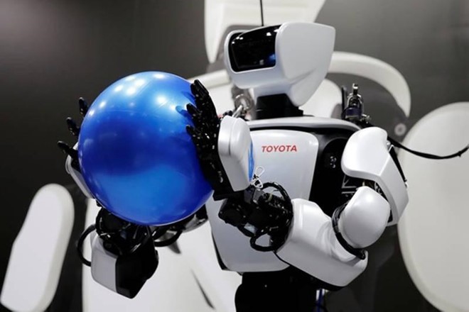 Robot T-HR3 của Toyota, nặng 75kg và cao 1,5m, đang cầm một quả bóng. Ảnh: Reuters.