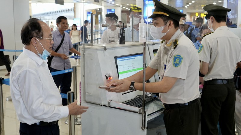 Hành khách sử dụng tài khoản VNeID trên điện thoại để làm thủ tục lên máy bay