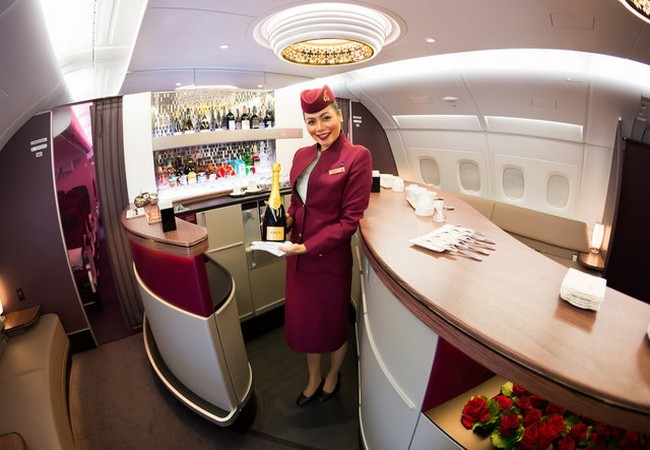 Một tiếp viên hàng không chào đón khách khi họ bước lên máy bay thuộc hãng Qatar Airways (Ảnh Shutterstock)
