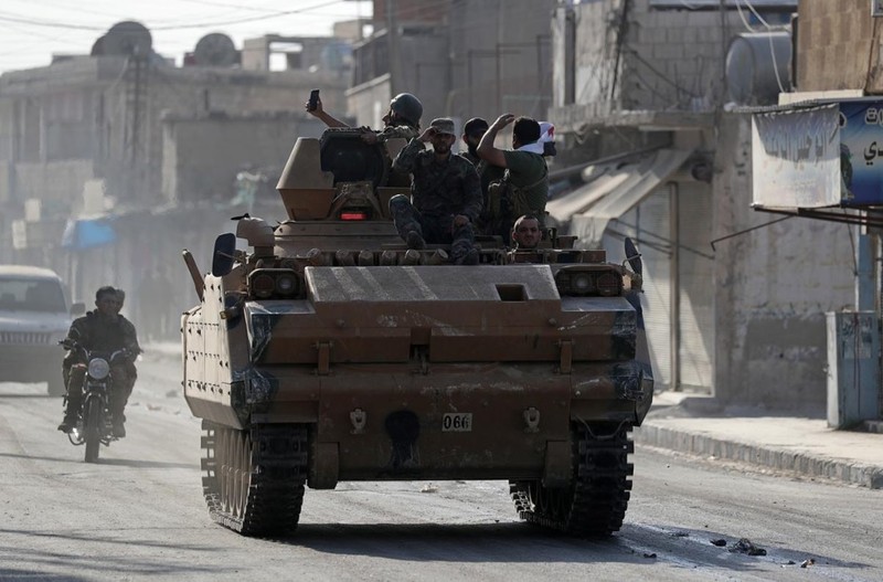 Các chiến binh nổi dậy Syria do Thổ Nhĩ Kỳ hậu thuẫn trên một chiếc xe quân sự ở thị trấn Tal Abyad, Syria (Ảnh: Reuters)