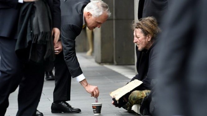 Ông Malcolm Turnbull cho tiền người ăn xin trên đường phố Melbourne hôm 18/8 - Ảnh: AAP