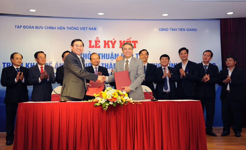 Chủ tịch UBND tỉnh Tiền Giang Nguyễn Văn Hưởng (trái) và Chủ tịch VNPT Trần Mạnh Hùng (phải) ký thỏa thuận hợp tác xây dựng Mỹ Tho trở thành Smart City.