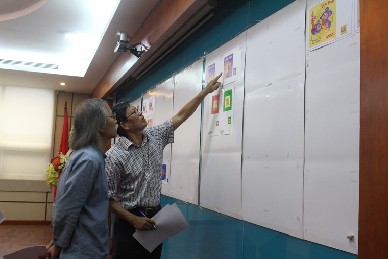 Các thành viên Hội đồng chấm thi xem xét, đánh giá và lựa chọn các mẫu tem Tết. Ảnh: MIC.gov.vn