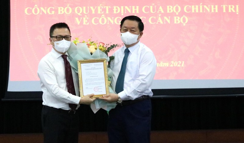 Ông Lê Quốc Minh nhận quyết định và hoa chúc mừng từ ông Nguyễn Trọng Nghĩa.