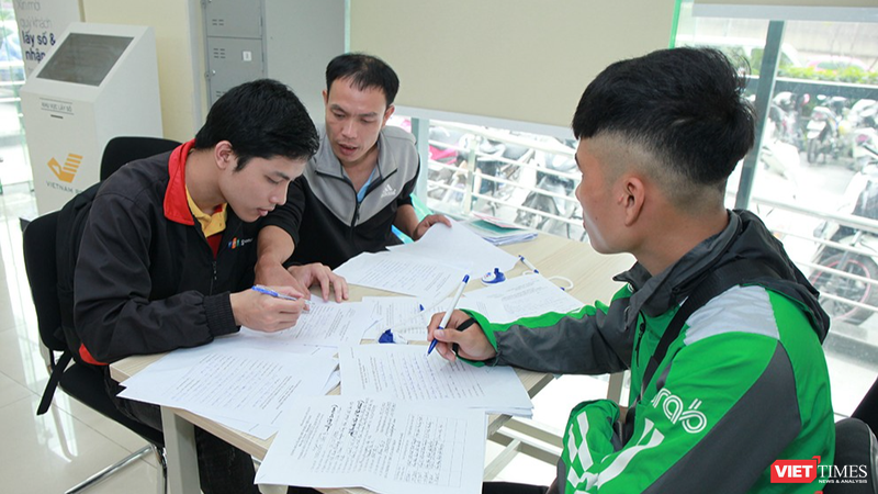 Nhân viên Bưu điện hướng dẫn khách hàng làm thủ tục đăng ký cấp phiếu lý lịch tư pháp tại bưu cục Thăng Long.