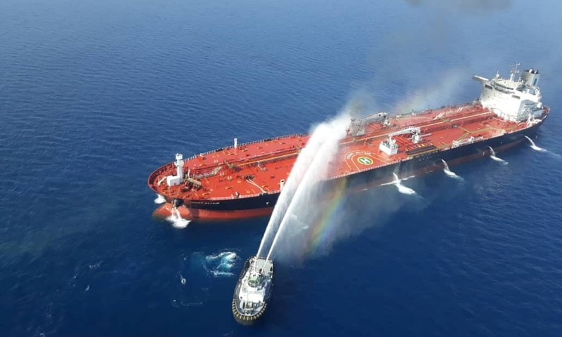 Một tàu của Iran cố gắng dập lửa cho con tàu bị tấn công trên vịnh Oman (Ảnh: Reuters)