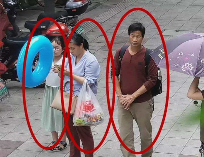 Bức ảnh trích xuất từ camera an ninh cho thấy cô bé Zhang Zixin bị 2 người lớn dẫn đi (Ảnh: Getty)